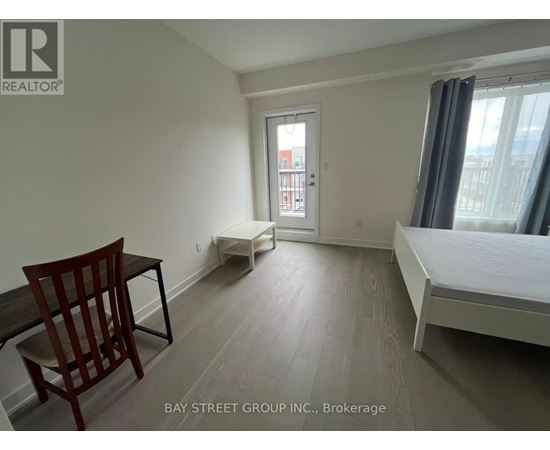 A bedroom with a bed, chair, and window.