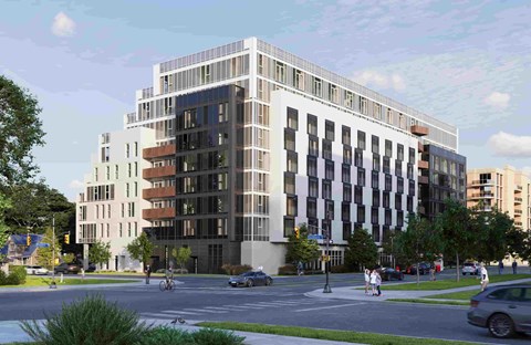 A modern multi-story building with a mix of white and darker colored windows is depicted.