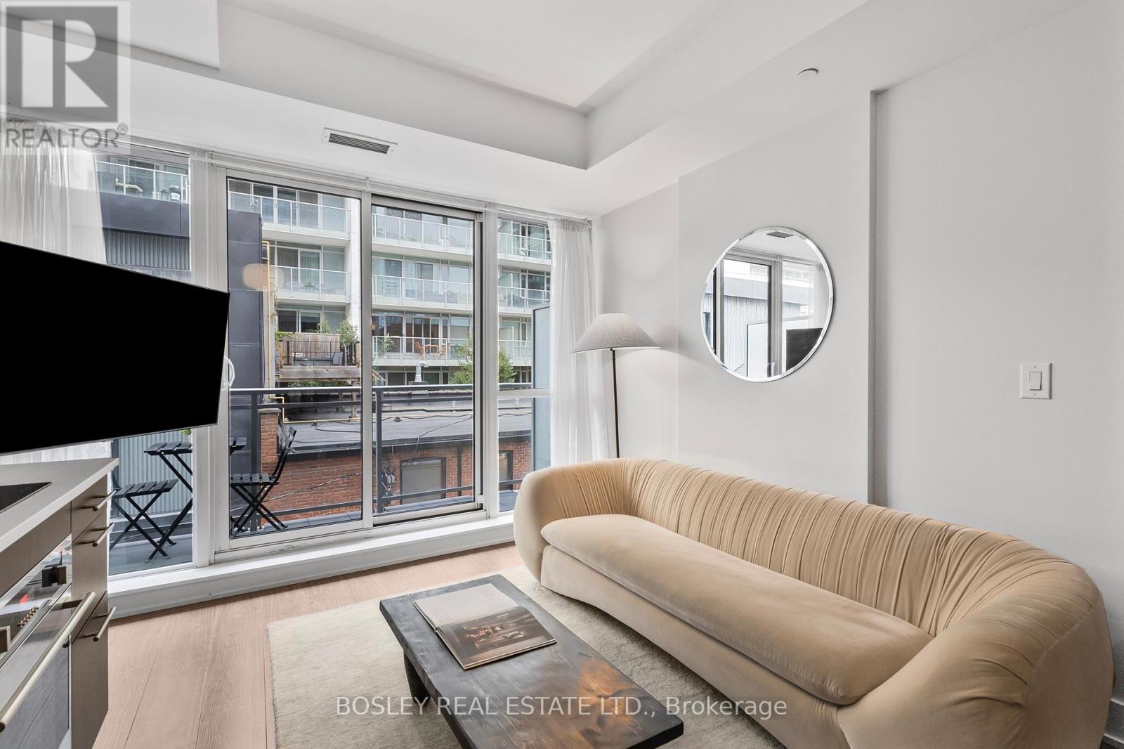 A living room with a large window and a view of a balcony.