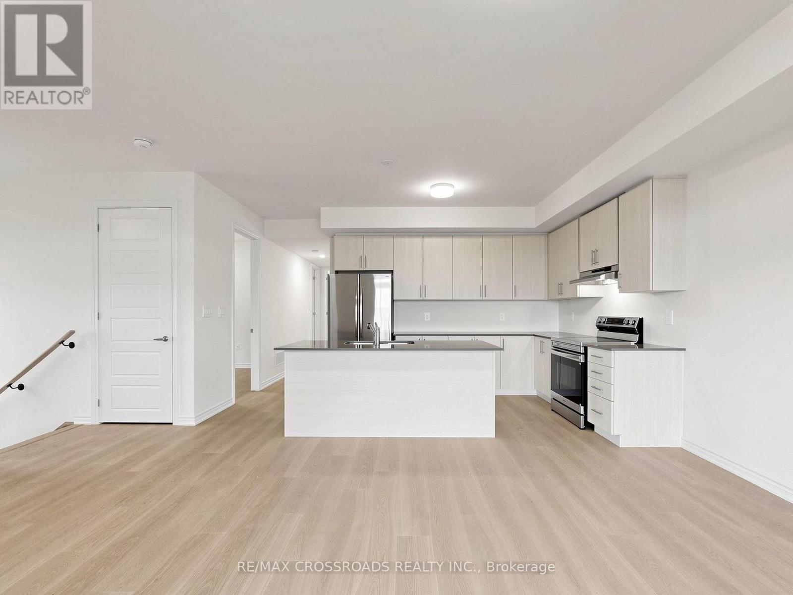 A spacious kitchen with white cabinets and a wooden floor.