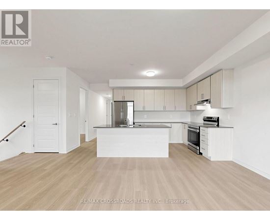 A spacious kitchen with white cabinets and a wooden floor.
