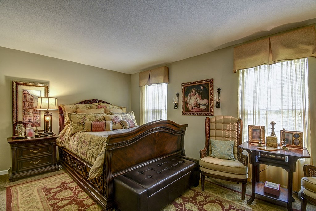 a bedroom with a bed and a chair and a table