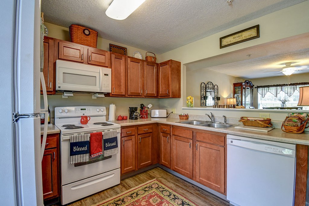 a kitchen with white appliances and wooden cabinets