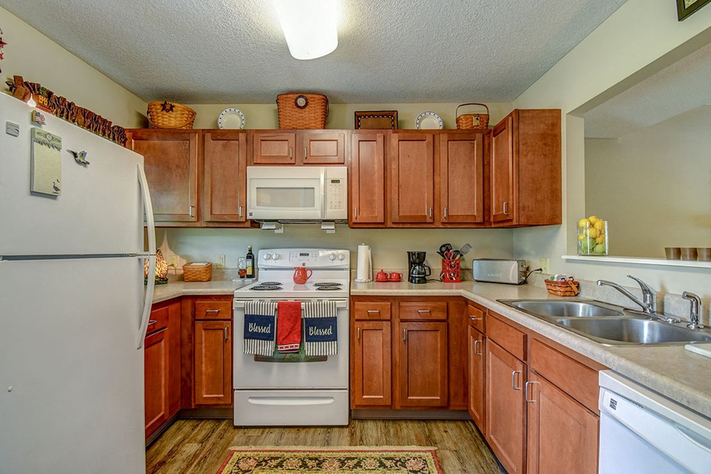 a kitchen with white appliances and wooden cabinets
