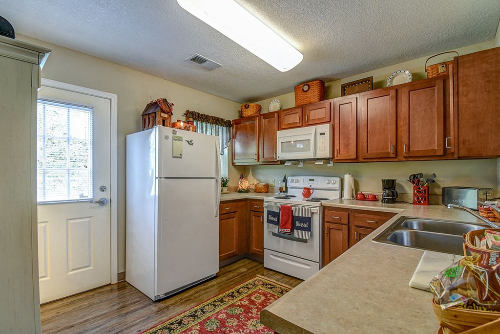 a kitchen with white appliances and wooden cabinets