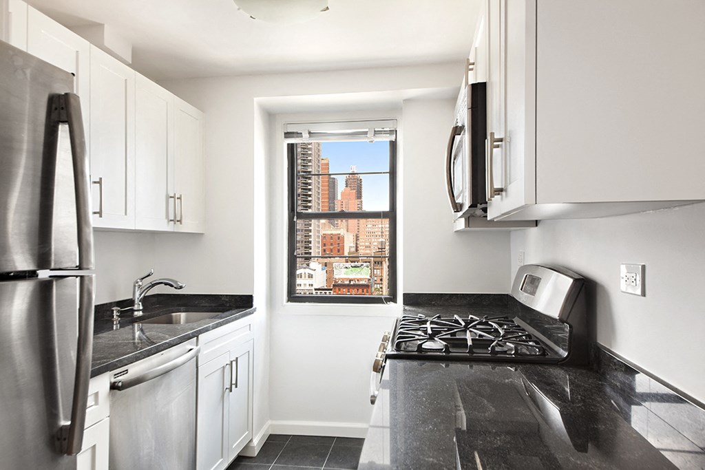 a kitchen with black counter tops and a window