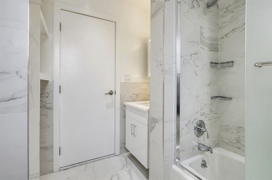 a white bathroom with a shower and a sink