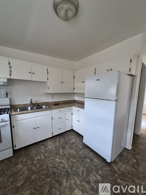 A kitchen with white appliances and cabinets.