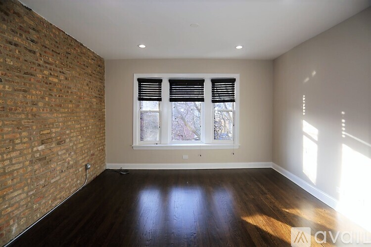 A room with a brick wall and wooden flooring.