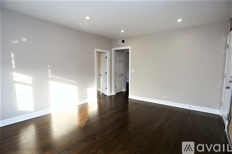 A spacious room with wooden floors and white walls.