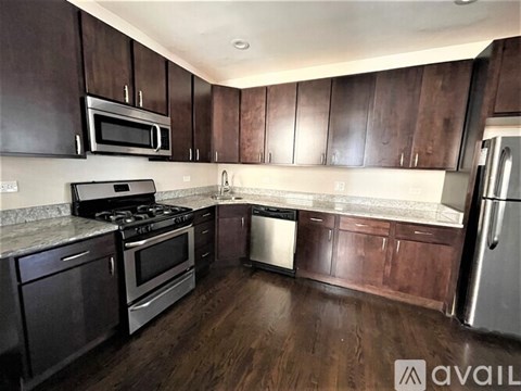 A kitchen with dark wood cabinets and stainless steel appliances.