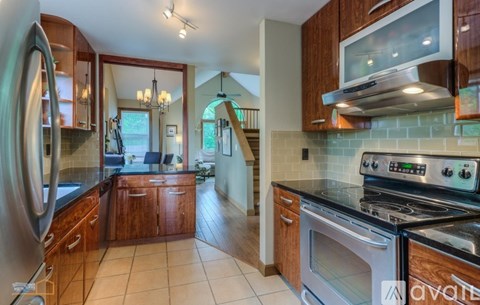A kitchen with wooden cabinets and a stainless steel refrigerator.