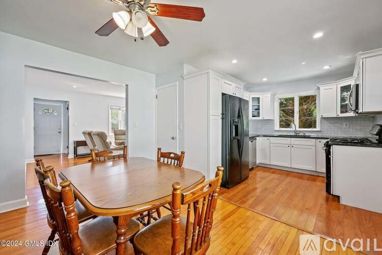 A dining room with a wooden table and chairs.