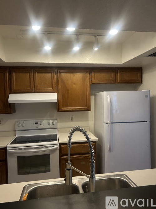 A kitchen with a white stove and a white refrigerator.