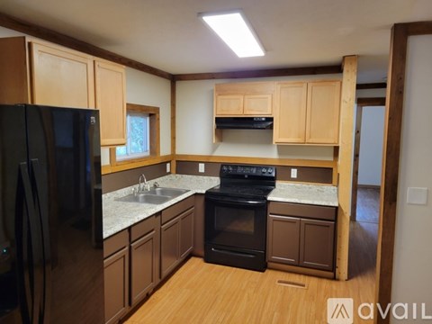 A kitchen with wooden cabinets and black appliances.