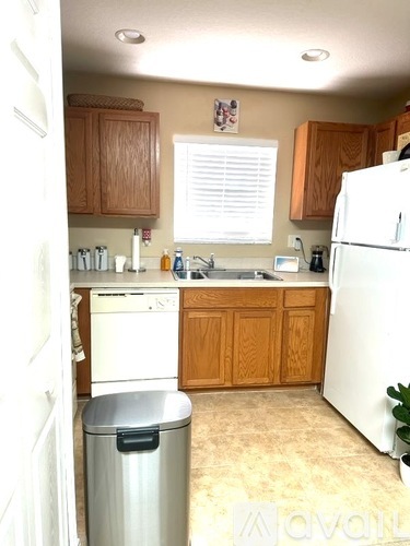 A kitchen with wooden cabinets and a white refrigerator.