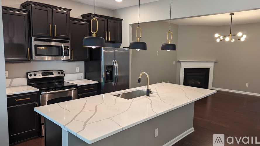 A kitchen with a white countertop and black cabinets.