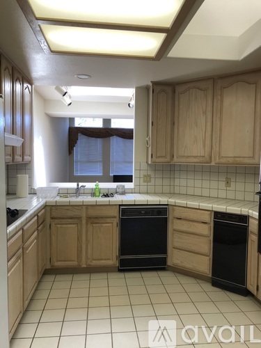 A kitchen with wooden cabinets and black appliances.