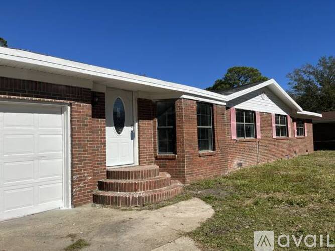A house with a white garage door and brick walls.