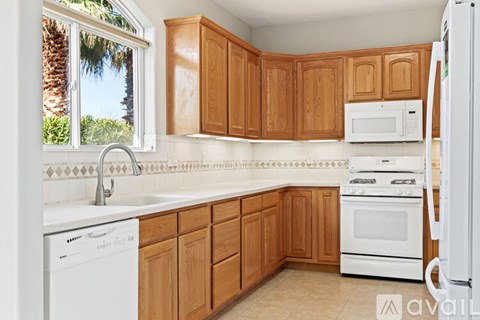 A kitchen with wooden cabinets and white appliances.