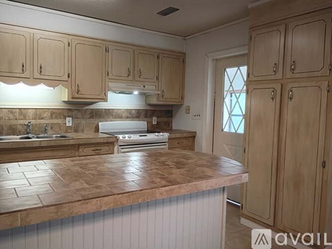A kitchen with wooden cabinets and a marble countertop.