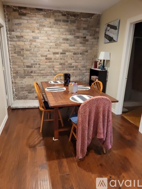 A dining room with a wooden table and chairs.