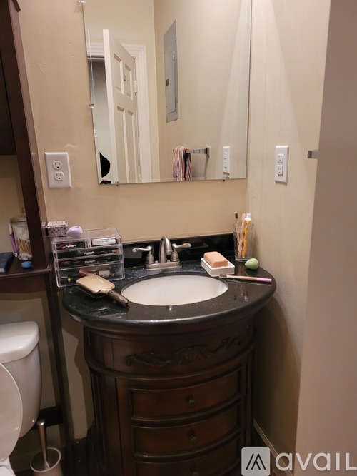 A bathroom with a sink, mirror, and toilet.