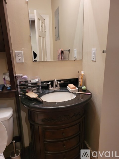 A bathroom with a sink, mirror, and toilet.