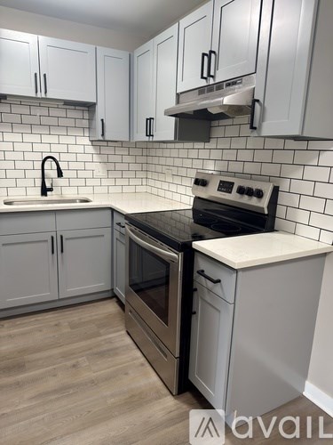 A kitchen with white cabinets and a black stove top oven.