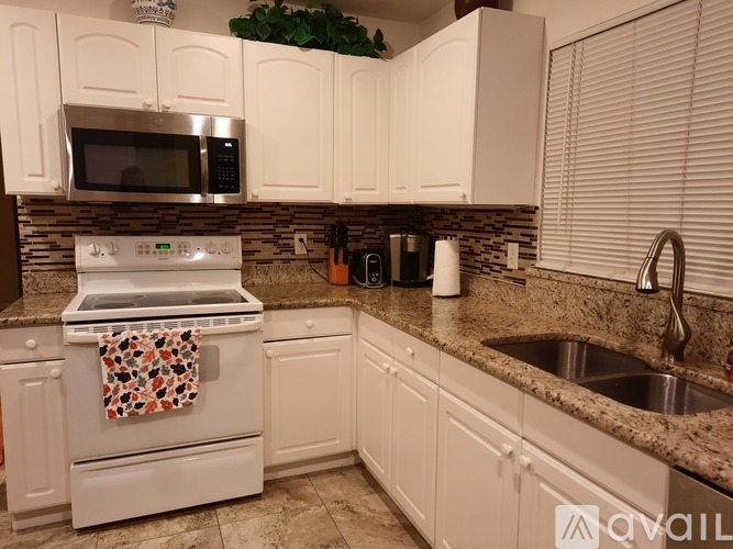 A kitchen with a white oven and microwave.