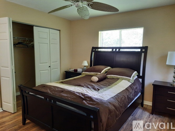 A bedroom with a large bed and a ceiling fan.