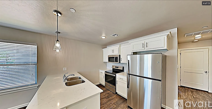 A kitchen with white cabinets and a stainless steel refrigerator.