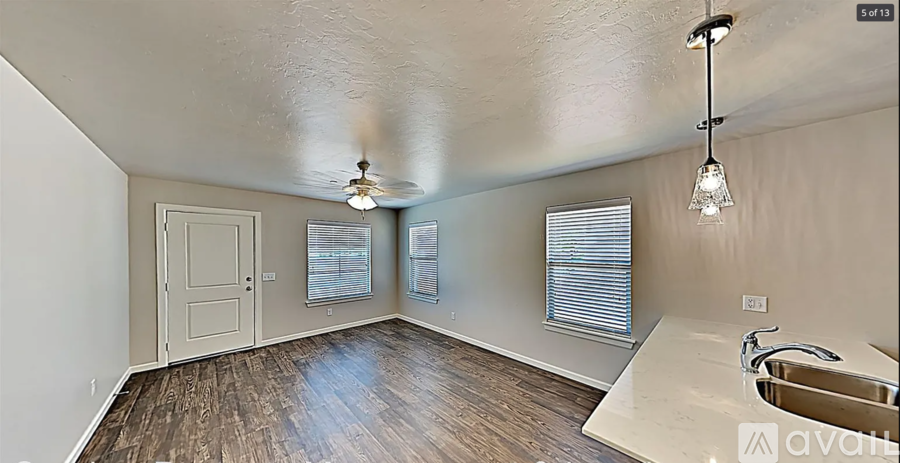 A room with a sink and a window with blinds.