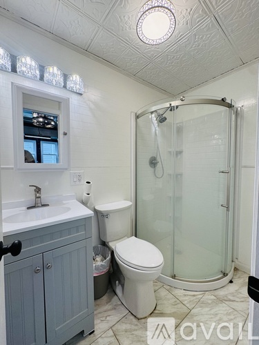 A bathroom with a toilet, sink, and shower.