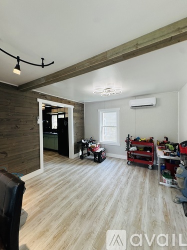 A room with wooden walls and a white ceiling with lights and a window.