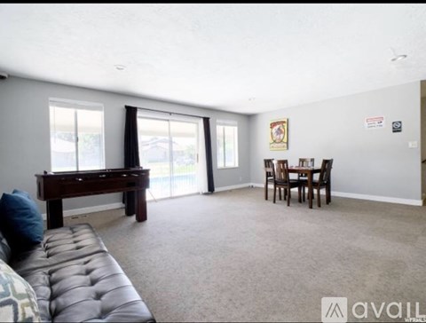 A living room with a brown couch and a dining table.