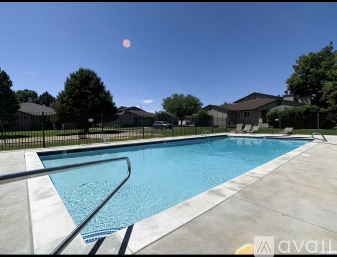 A pool with a slide and a fence around it.