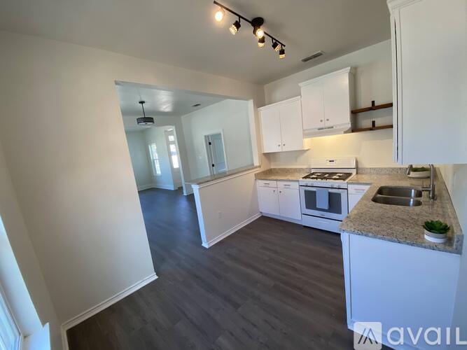 A kitchen with white cabinets and a granite countertop.