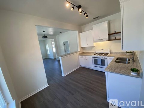 A kitchen with white cabinets and a granite countertop.