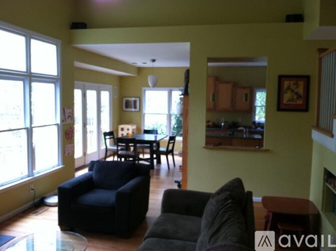 A living room with a black couch and a dining table.