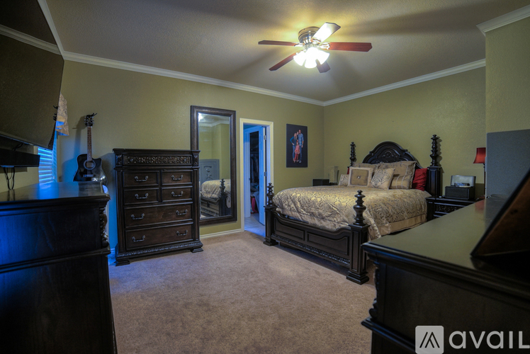 A bedroom with a bed, dresser, and mirror.