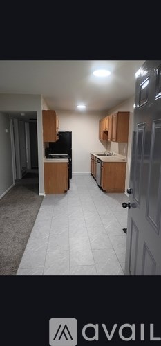 A kitchen with wooden cabinets and a black refrigerator.