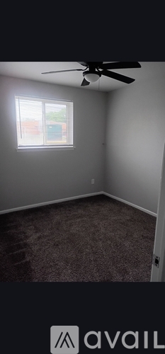 A room with a ceiling fan and a window.