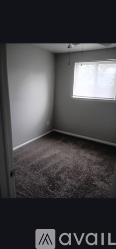 A room with a window and carpeted floor.