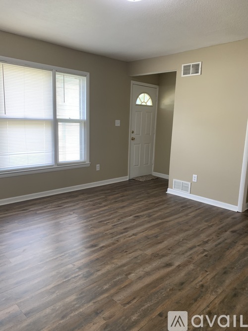 A room with wooden floors and a white door.