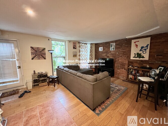 A living room with a couch, a chair, a table, and a bookshelf.