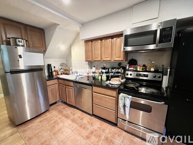 A kitchen with a stainless steel refrigerator, microwave, and oven.