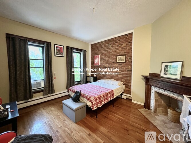 A bedroom with a brick wall and a fireplace.