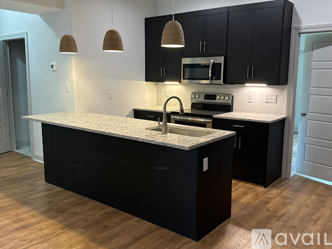 A kitchen with black cabinets and a granite countertop.