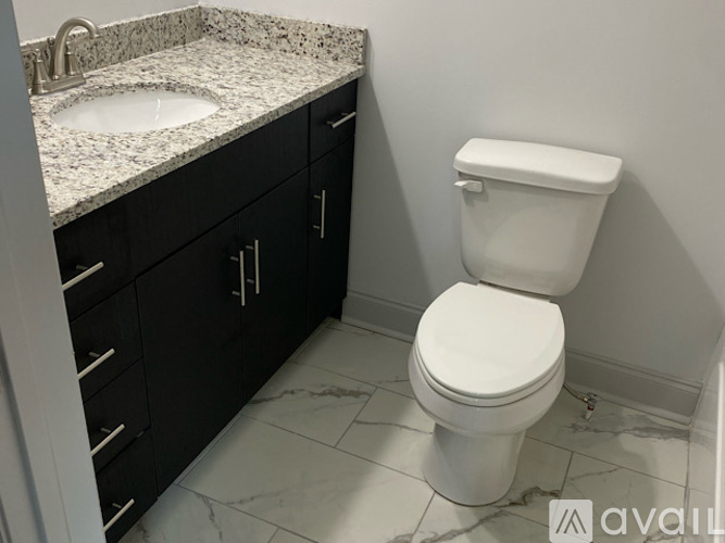 A white toilet sits next to a sink in a bathroom.